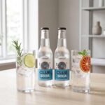 Hammars Bryggeri Club Soda i glasflaskor tillsammans med serverade drinkar med is, lime och örter