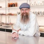 Jens Josefsson från GinSweden lutar sig mot en bardisk med ett kupaglas Gin & Tonic