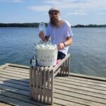 Jens Josefsson på en brygga med ett kupaglas och en ishink fylld med Hammars Bryggeri Tonic