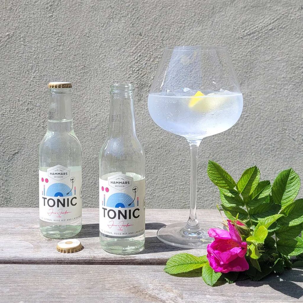 Hammars Bryggeri Tonic Citrus Rose Hip Læsø Salt glasflaskor bredvid Gin och Tonic i kupaglas med nyponros